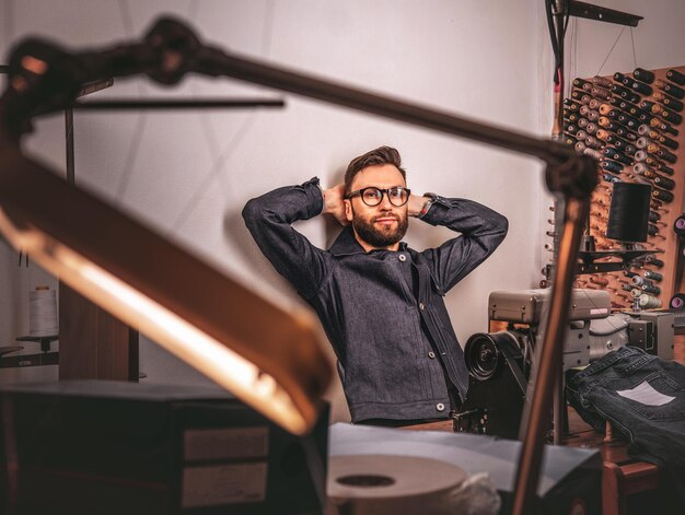 Handsome bearded fashion designer taking a break from work and thinking about new designs.