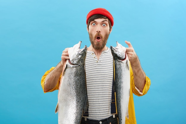 Free photo handsome bearded fisherman posing against blue background