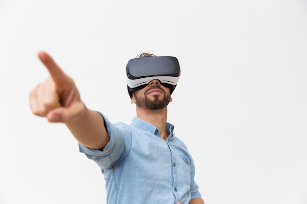 Handsome bearded guy wearing VR glasses, touching air