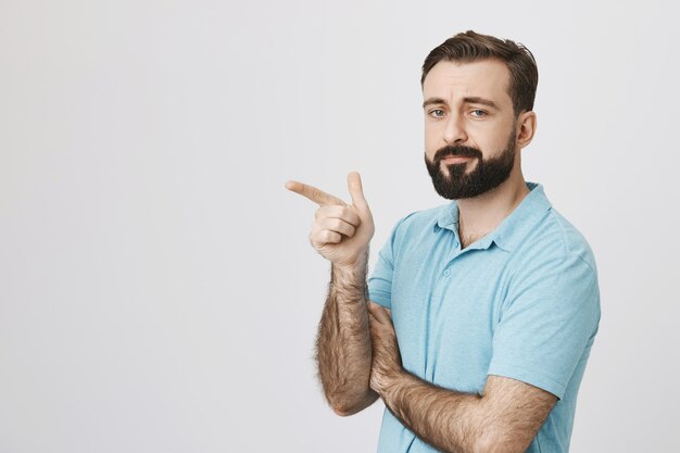 Handsome bearded male customer making choice, pointing left