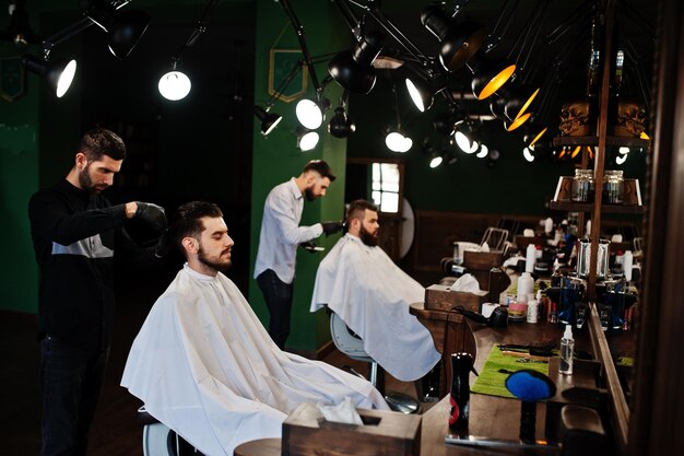 Handsome bearded man at the barbershop barber at work