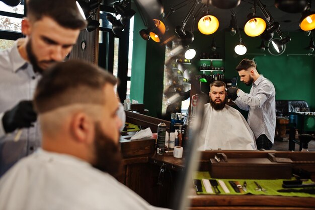 Handsome bearded man at the barbershop barber at work