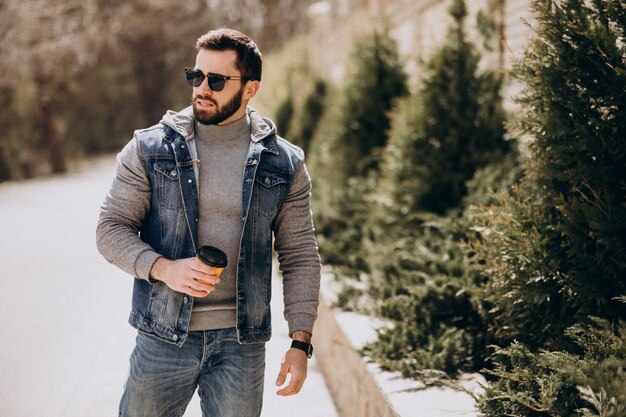 Handsome bearded man drinking coffee outside the street