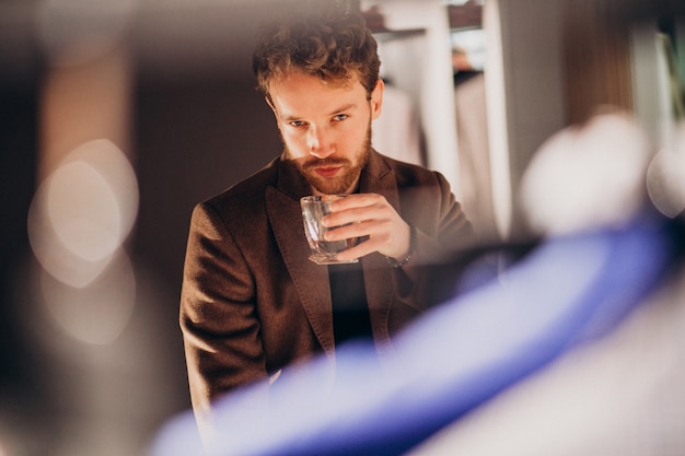 Handsome bearded man drinking whiskey