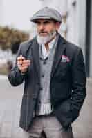 Бесплатное фото Красивый бородатый мужчина курит сигарету