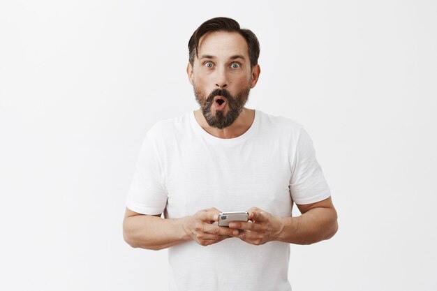 Handsome bearded mature man posing with his phone