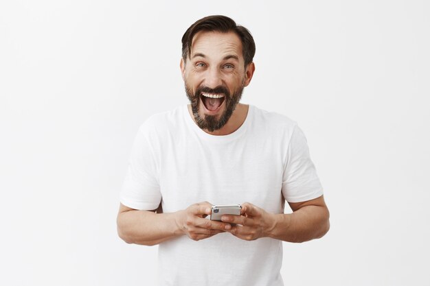 Handsome bearded mature man posing with his phone