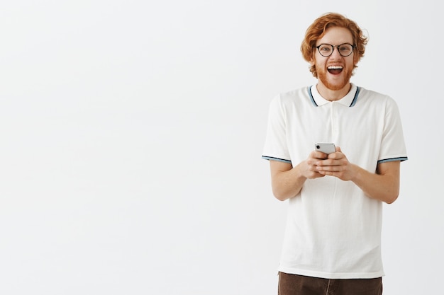 Handsome bearded redhead man using mobile phone