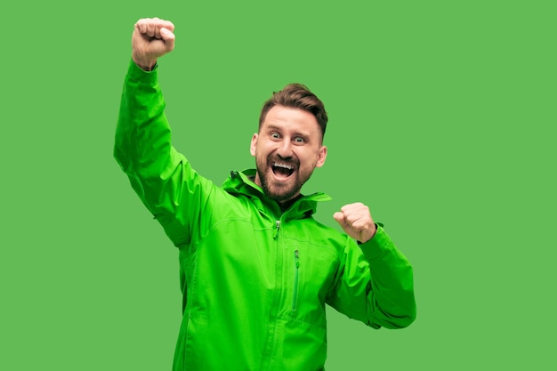 Handsome bearded smiling happy young man looking at front isolated on vivid trendy green studio