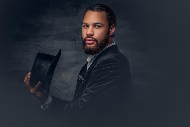 Free photo handsome black bearded male dressed in a suit from a wool and cylinder hat.