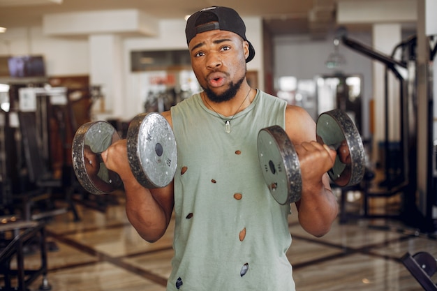 Free photo a handsome black man is engaged in a gym