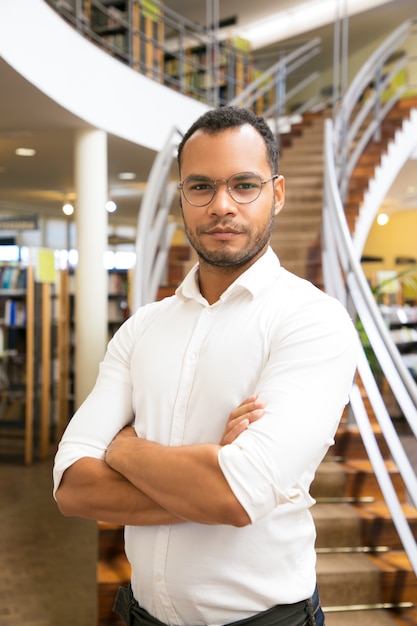 Uomo di colore bello che posa alla biblioteca pubblica