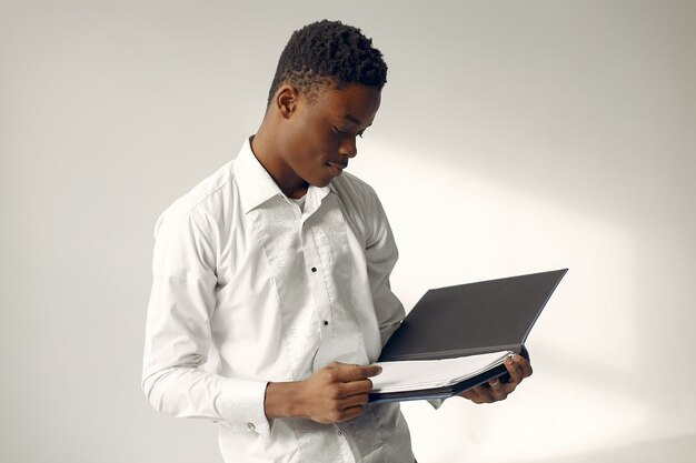 Handsome black man standing on a white wall