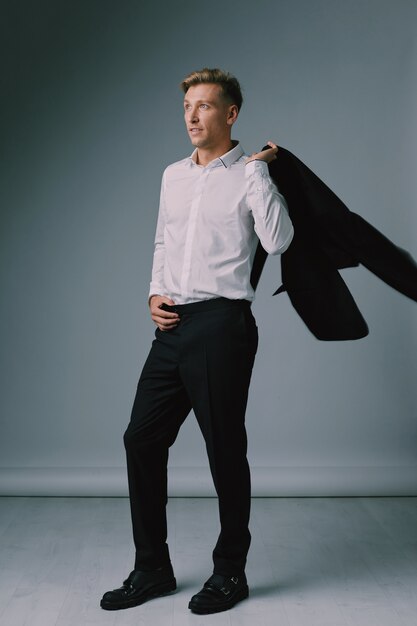 Handsome blond young man posing with elegant suit