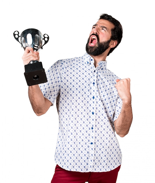 Free photo handsome brunette man with beard holding a trophy