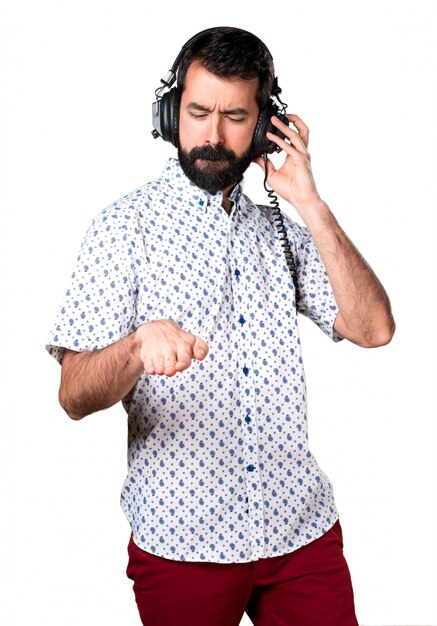 Handsome brunette man with beard listening music