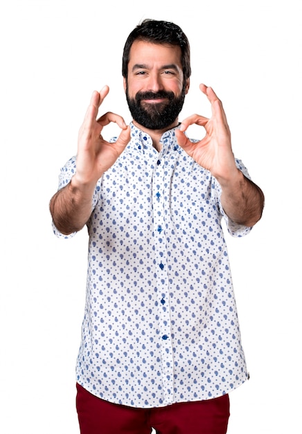 Handsome brunette man with beard making OK sign