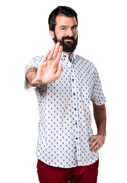 Handsome brunette man with beard making stop sign