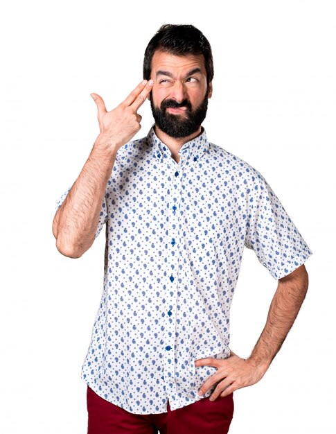 Handsome brunette man with beard making suicide gesture