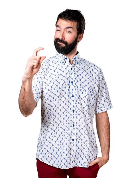 Handsome brunette man with beard making tiny sign