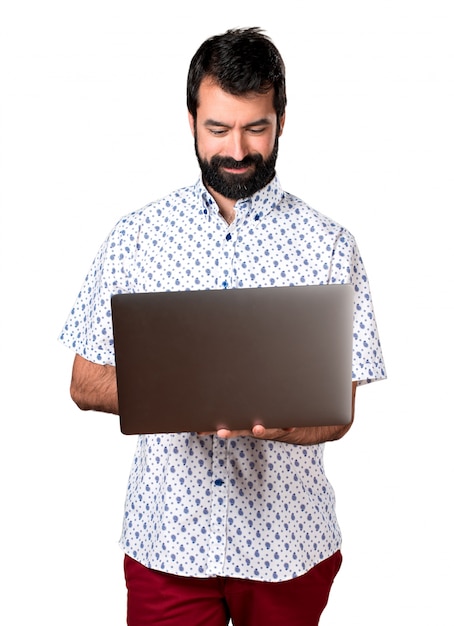 Free photo handsome brunette man with beard with laptop