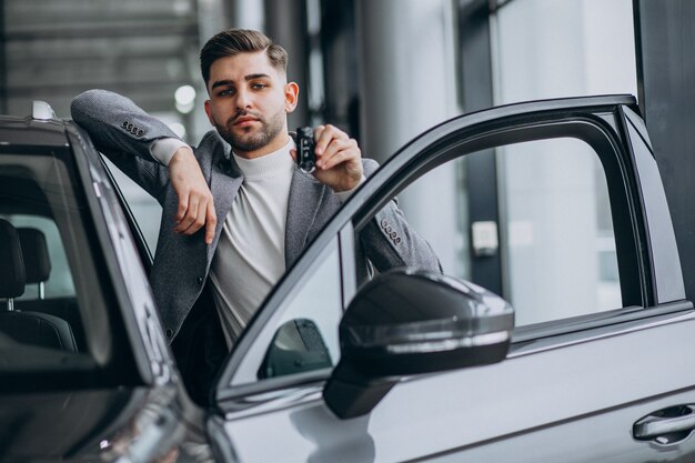 Handsome business man choosing a car in a car showroom