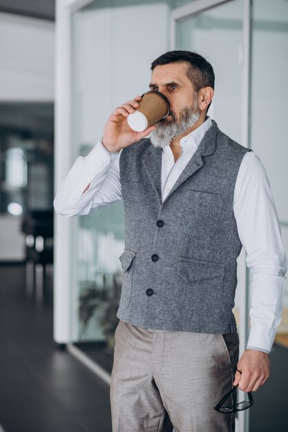 オフィスでコーヒーを飲むハンサムなビジネスマン