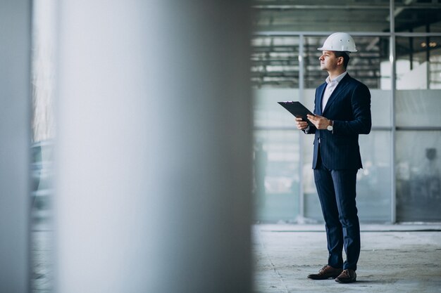 handsome business man engineer in hard hat in a building