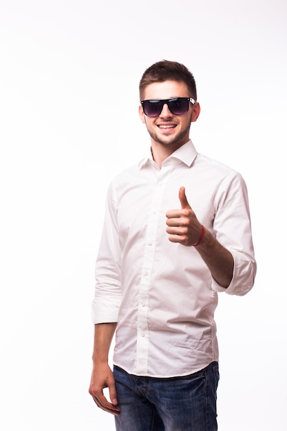 Handsome business man leaning on a white wall while showing thumbs up holding one hand in his pocket.