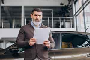 Бесплатное фото Красивый деловой человек читает документы об аренде автомобиля