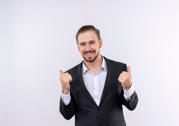 Handsome business man wearing suit crazy happy showing thumbs up standing over white background