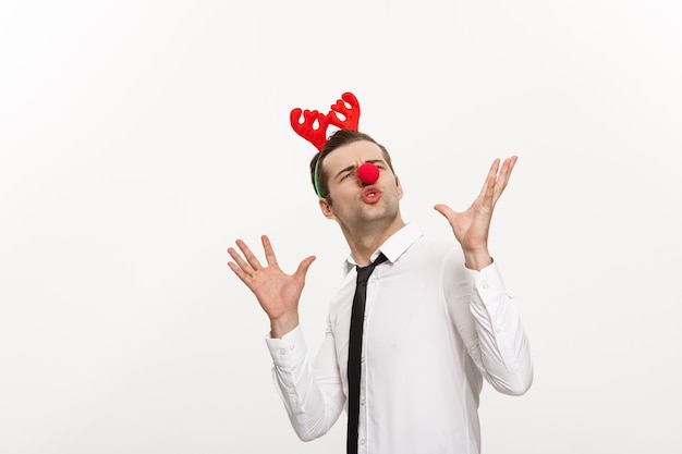 Foto gratuita bel uomo d'affari che indossa la fascia per capelli di renne rendendo divertente espressione facciale isolata su bianco.