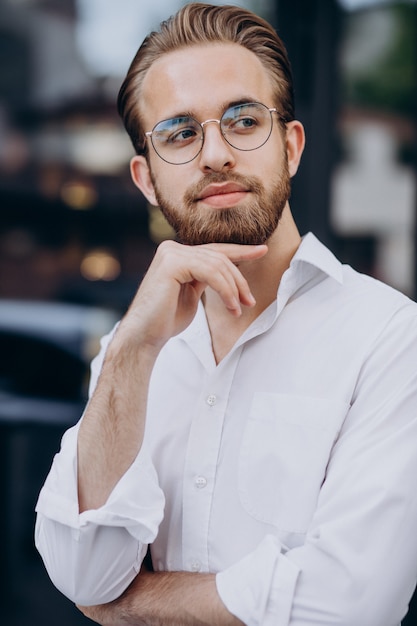 Handsome business man in white shirt walking at the street