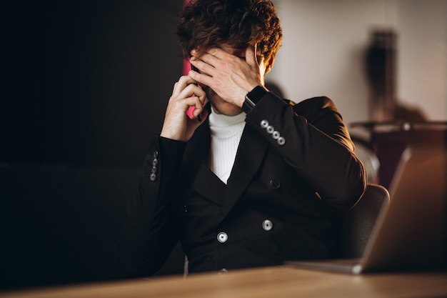 Uomo bello di affari che lavora al computer in ufficio