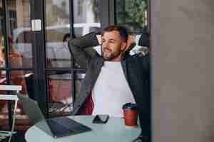 Free photo handsome business man working on laptop in cafe