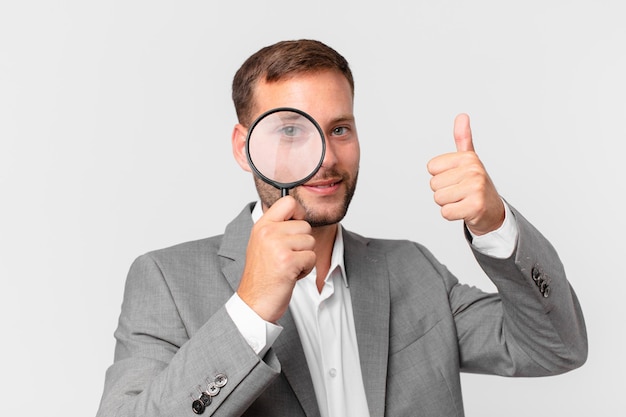 Handsome businessman finfing with a magnifying glass
