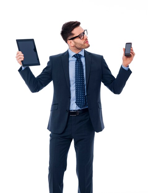 Handsome businessman holding in his hands digital tablet and mobile phone
