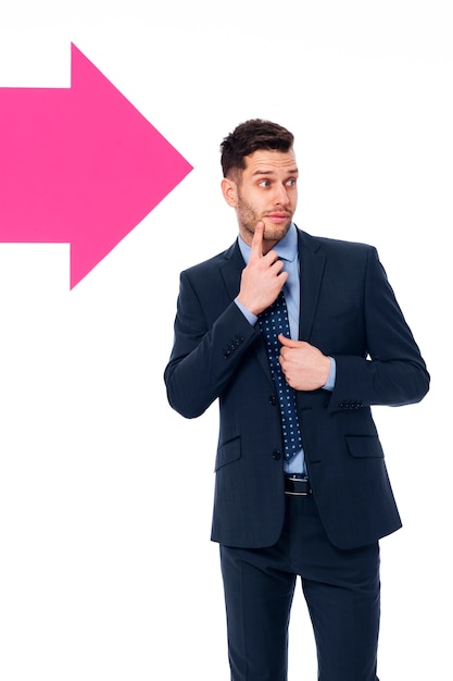 Handsome businessman looking in the direction in which the arrow showing