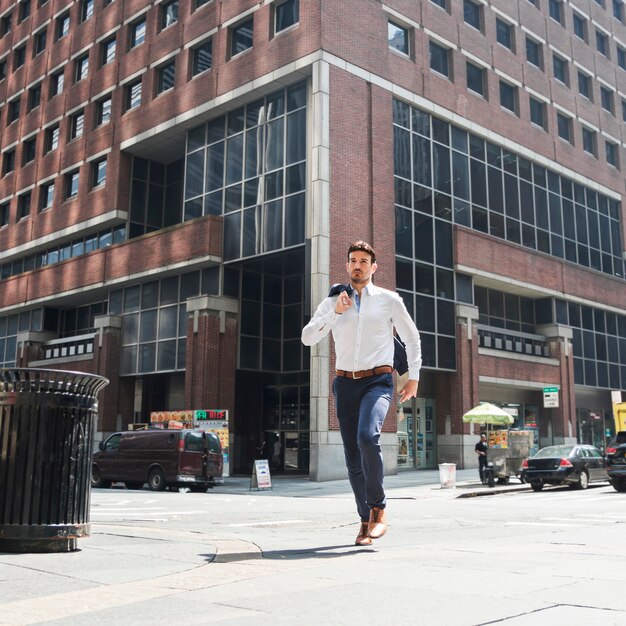 Handsome businessman running on street