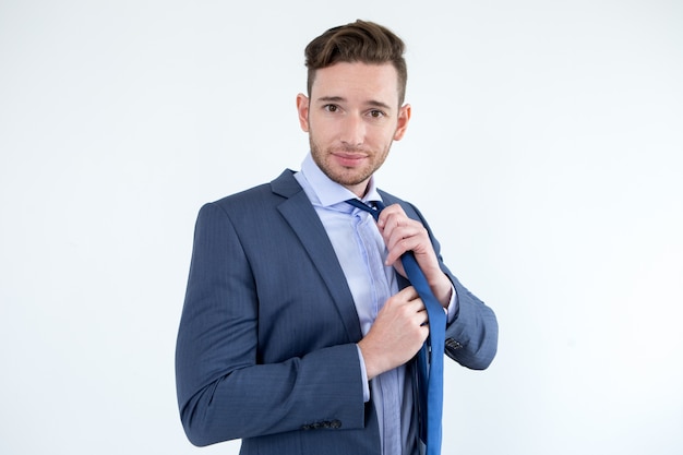 Handsome businessman taking off necktie