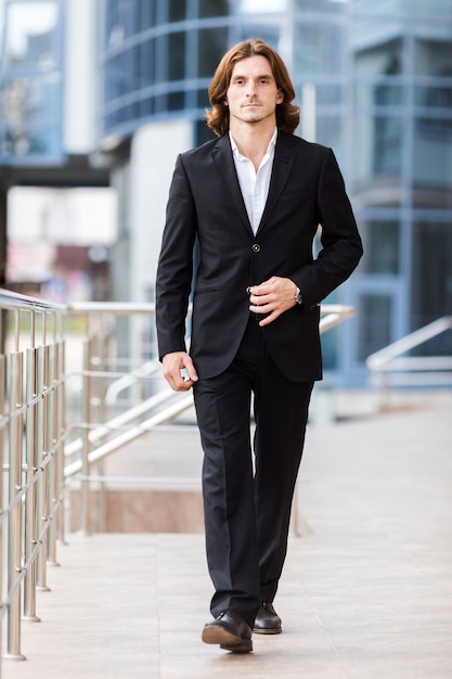 Handsome businessman walking to camera