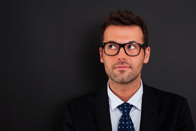Handsome businessman wearing glasses looking up