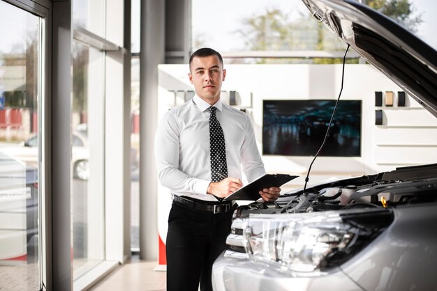 Handsome car dealer holding a clipboard