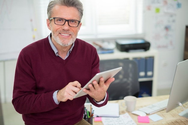 Handsome and cheerful man working on digital tablet
