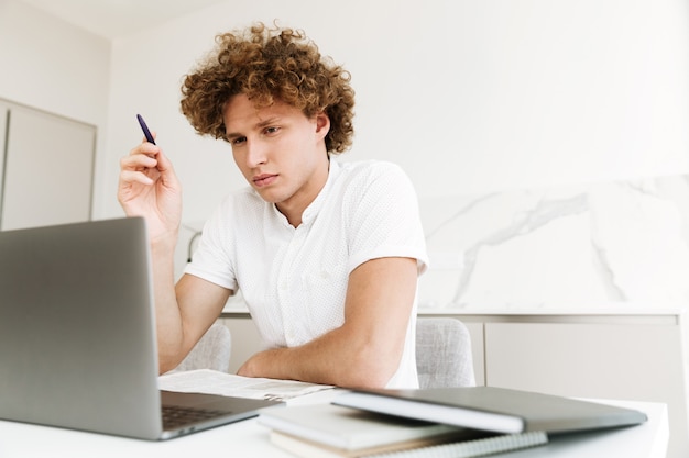 Free photo handsome concentrated serious man using laptop computer.