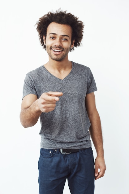 Handsome confident african man smiling pointing finger at camera.