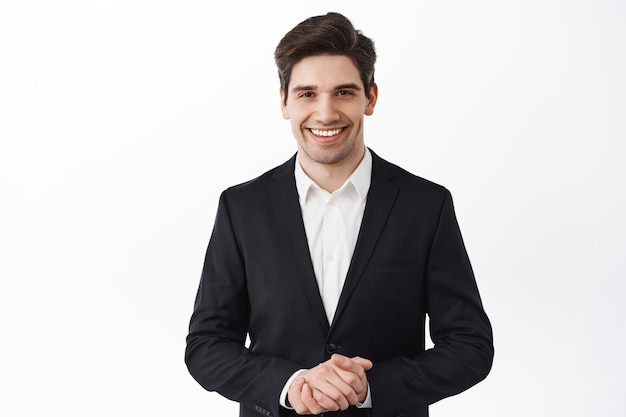 Handsome corporate man, real estate agent assistant smiling, hold hands together, how may I help you, smiling friendly and polite, assist customer, white background