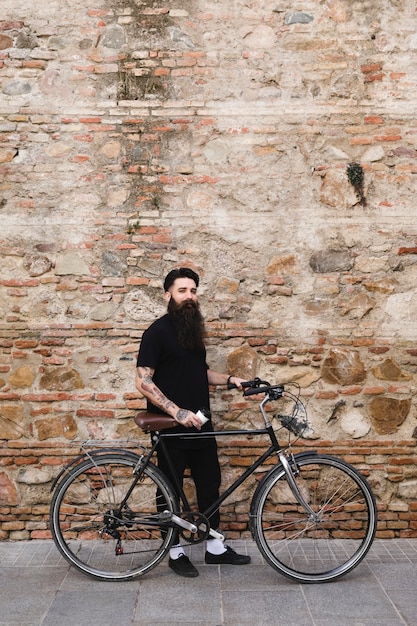 Handsome cyclist standing with bicycle