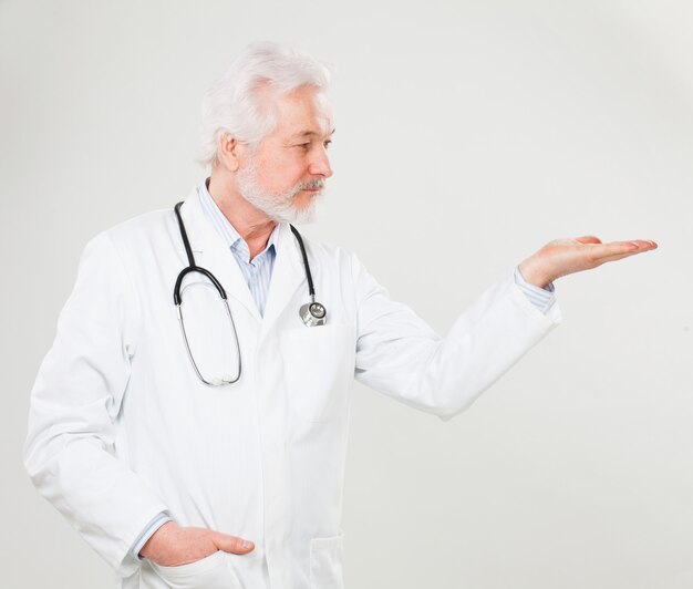 Handsome elderly doctor holds something