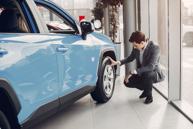 Foto gratuita uomo bello ed elegante in un salone di auto